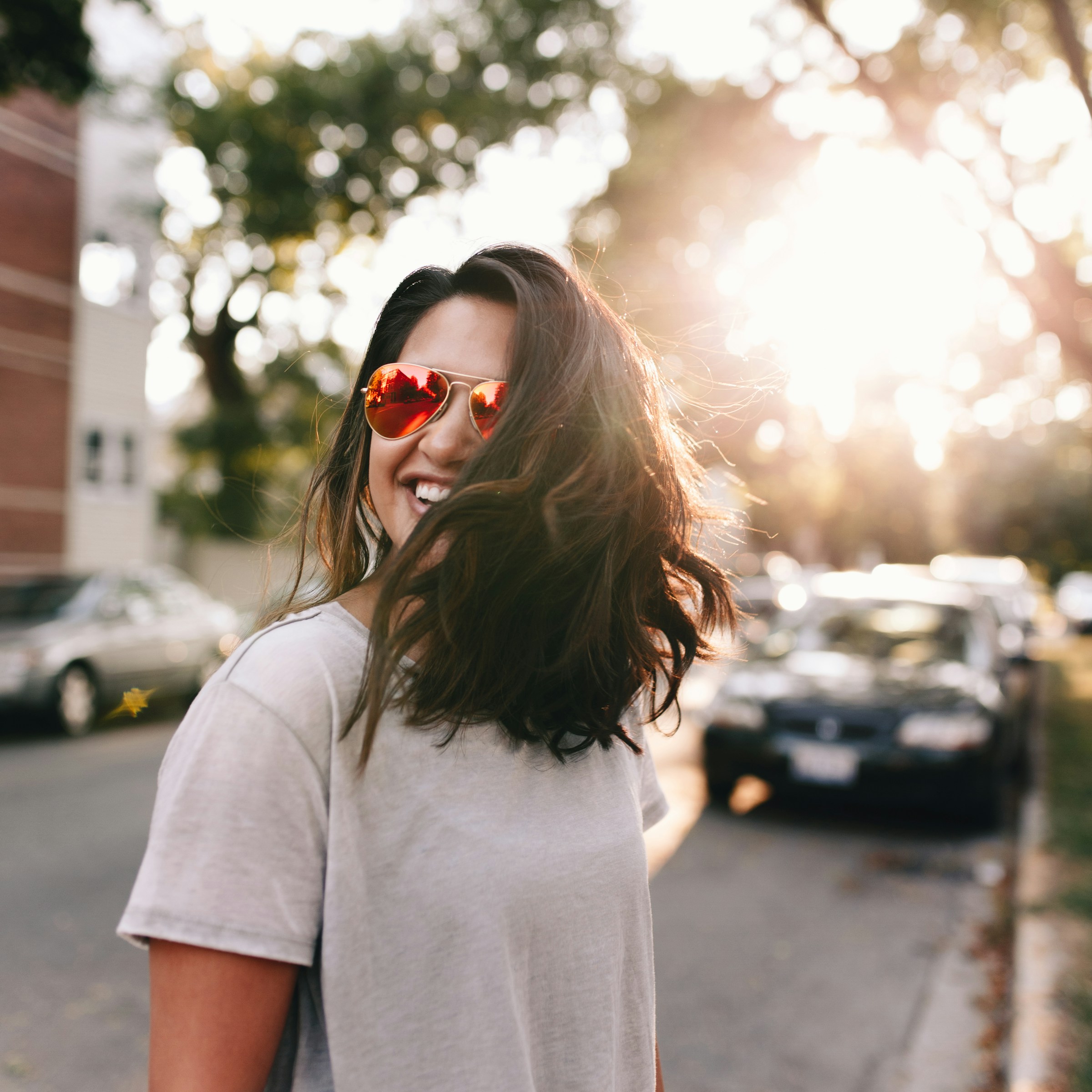 Woman wearing white T-shirt smiling.